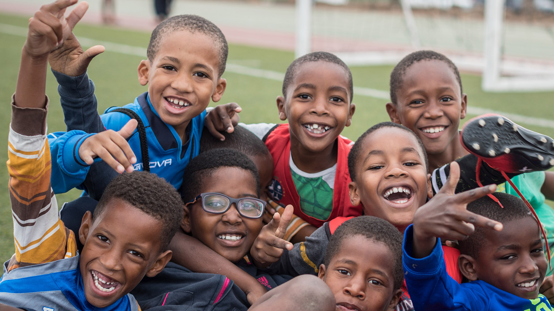 Criancas e jovens da EFAT sorridentes em campo
